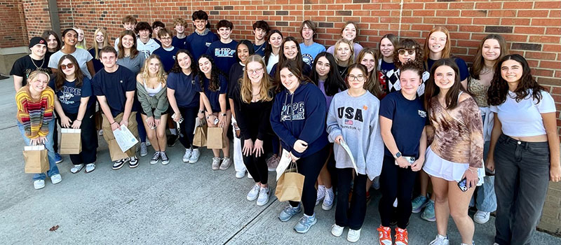 Pope students posing in front of a brick wall at Brumby